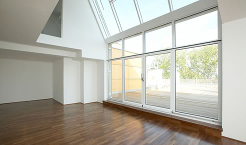 Helle Wohnung mit Parkettboden und großen Fenstern, die viel Tageslicht hereinlassen. Wohnraum der KWG Gröditz.